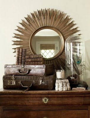 Bell jar, sunburst mirror, vintage suitcases